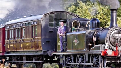 A steam tank engine pulling a vintage carriage on the Kent and East Sussex Railway